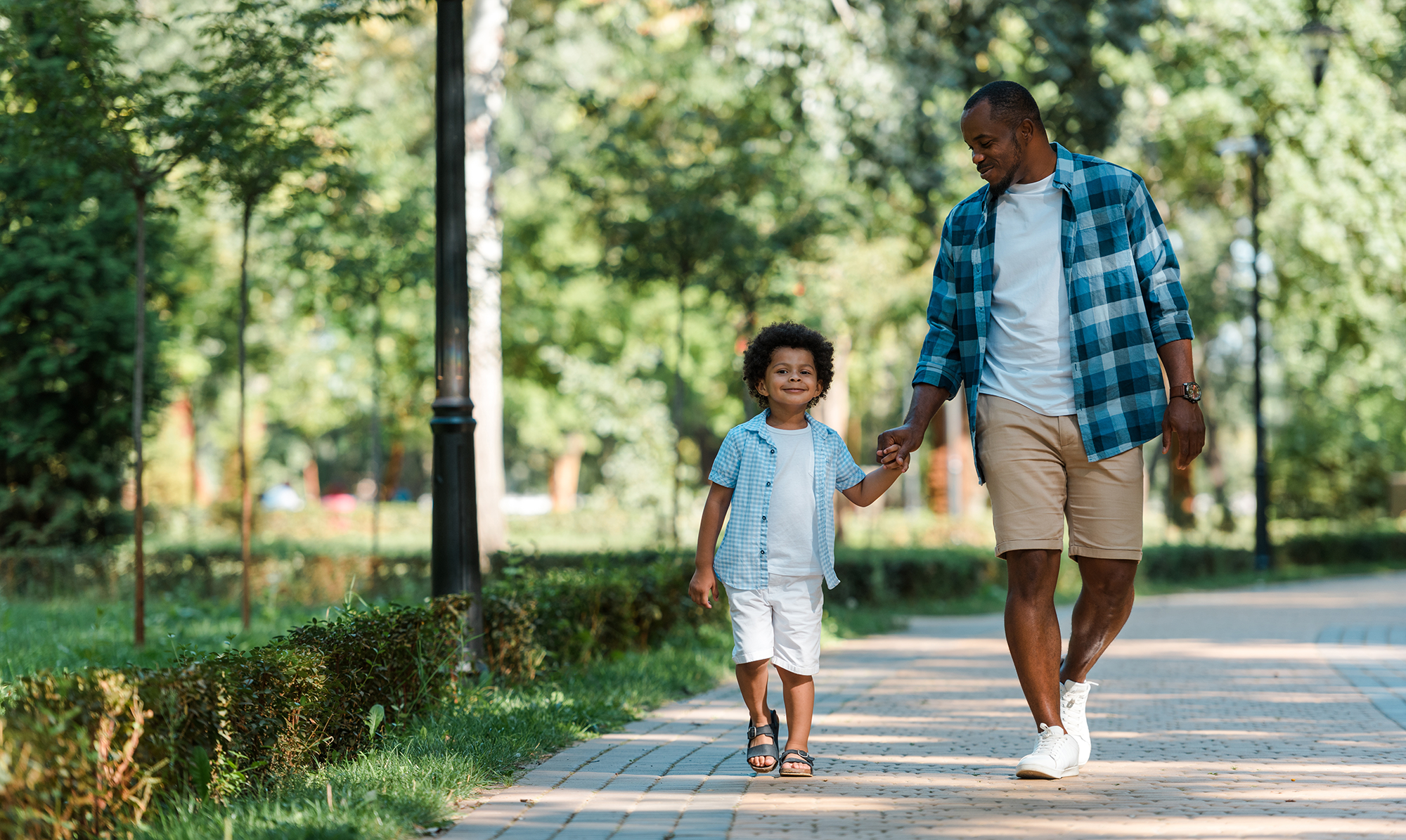 dad and young son on walk in park